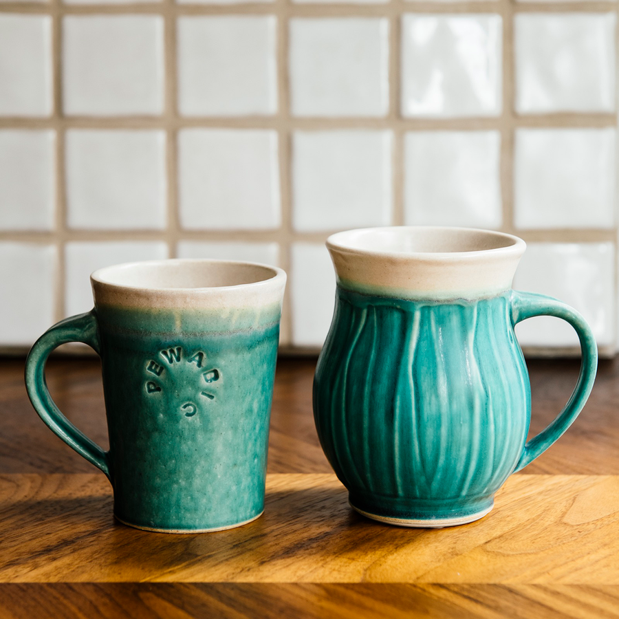 A photo comparing the Cafe Mug and the Classic mug shows that the cafe mug is slightly shorter than its Classic rounded counterpart.