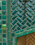 Detail shot of the fireplace that includes Iridescent and varying blue/green field tiles along with custom-cut tiles crafted specifically for this installation.