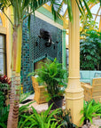 Sideview of the custom fireplace surrounded by lush, tropical plants.