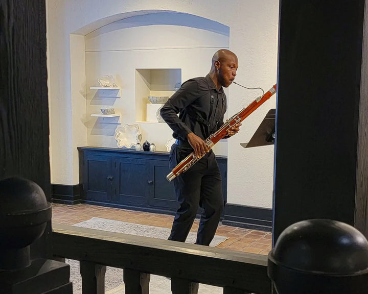 Bassoonist Jaquain Sloan playing while reading sheet music in Pewabic's upstairs galley.