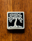 This ceramic black/white Botanical Tree tile features a white tree and border on a black background.