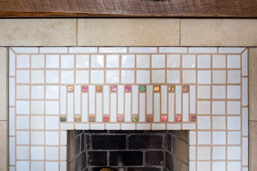 A close-up photo showcasing the subtle variations of our white Cloud, Creme, and Alabaster tiles. The Blush Iridescent accents at the center shine and reflect the sunshine from the window in this elegant space.