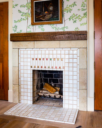 A detailed view of the fireplace and hearth in a portrait-style orientation. There are logs inside of the fireplace just waiting to be lit.