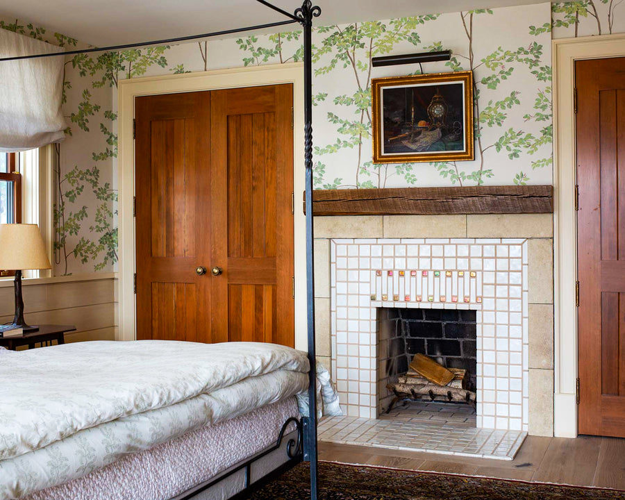 A sophisticated blend of white tiles with accents of our sunset-pink Blush Iridescent glaze set in a rustic-style bedroom scene with distressed wood mantle.