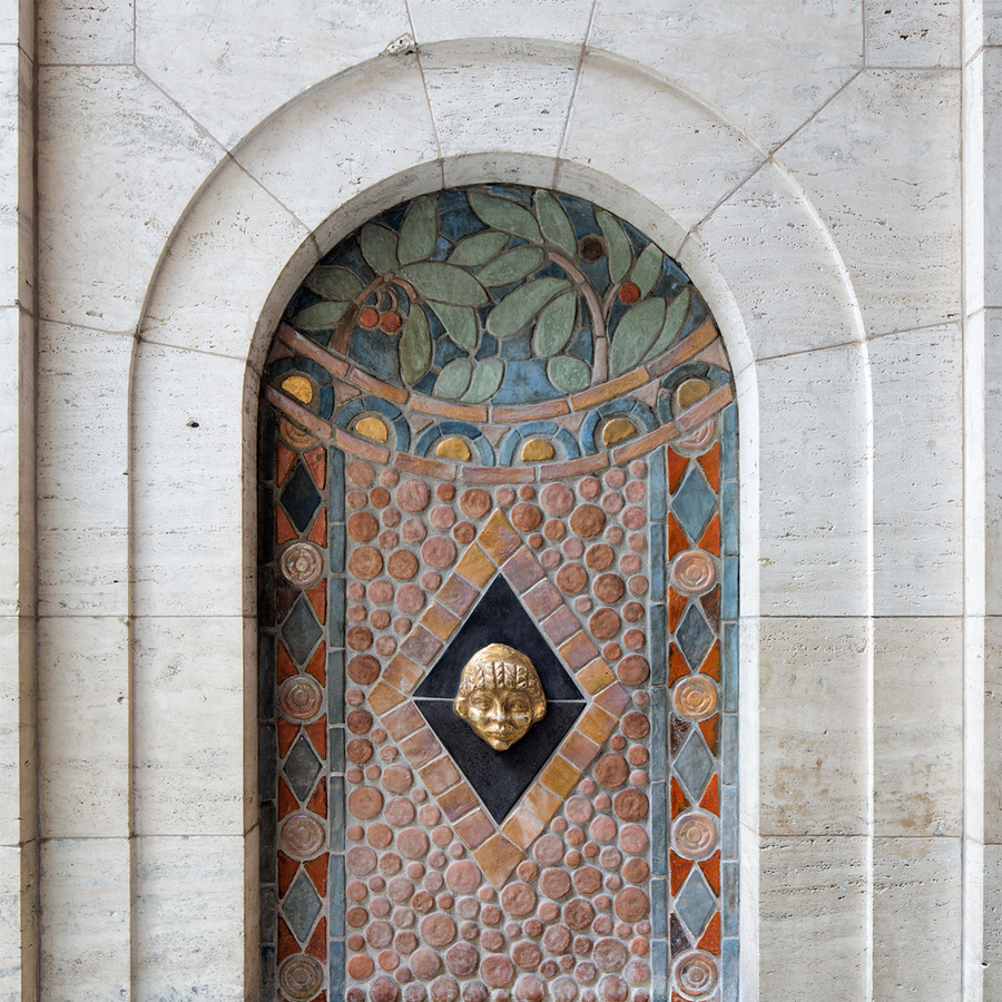 A detail of the historic water fountain found in the Detroit Institute of Arts shows leaves, berries, and tiles of all different shapes in a concentric pattern.