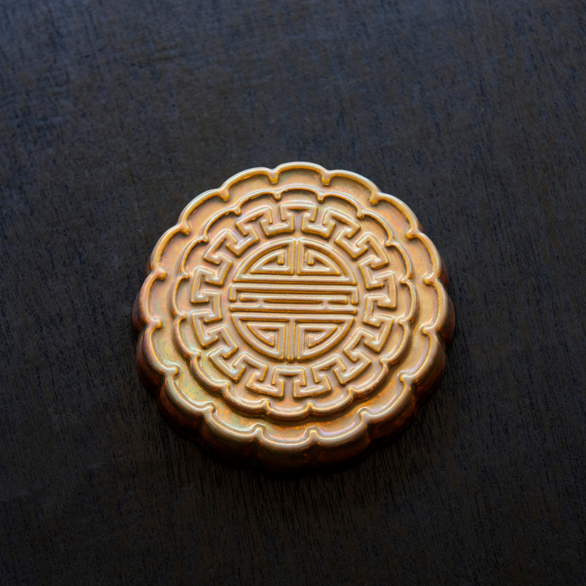 A Mooncake Paperweight in shimmering Blush Iridescent.  