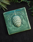This Ceramic 6X6 Pine Cone Tile is shown in the Leaf green glaze.