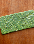 The Oak Leaves tile features high relief oak leaves and acorns hanging from a thin branch. The leaves are layered and giving the illusion of depth- like the many layers of leaves found on a flourishing tree. This tile features the matte bright light green Lime glaze.