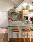 Multicolored tile backsplash in a kitchen with modern cabinets and a jade green countertop