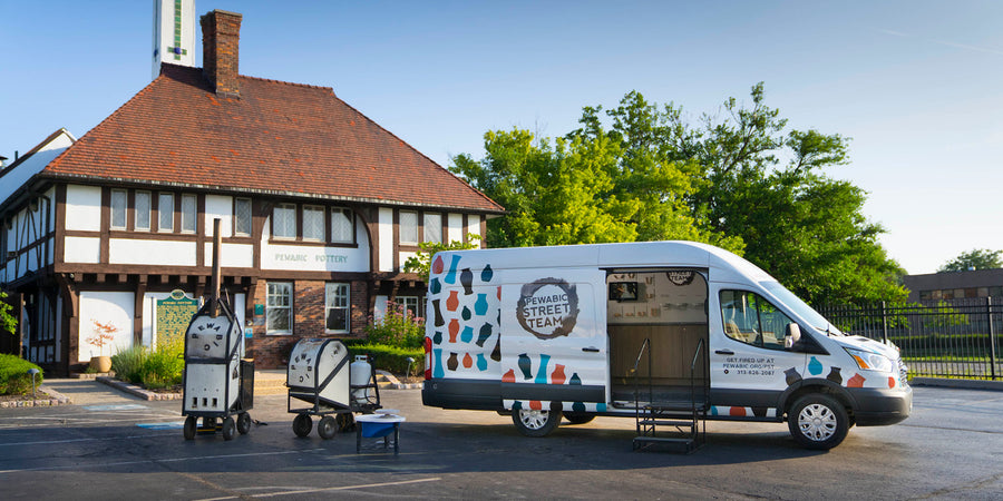 The large Pewabic Street Team van is parked in front of the historic pottery on a warm summer day.