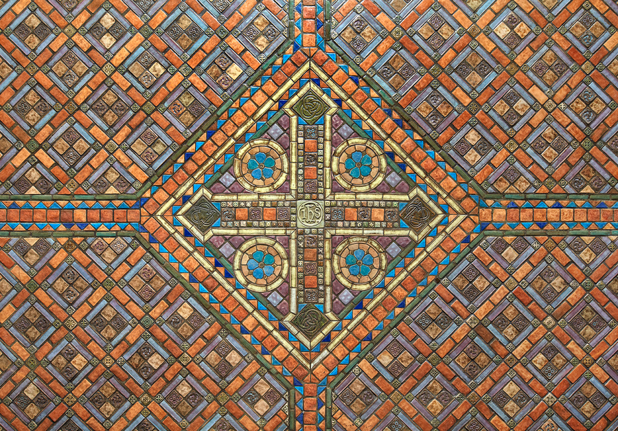 A detail of the intricate tile ceiling of the Basilica of the National Shrine of the Immaculate Conception in Washington, DC. The tiles form a cross design in red, brown, and blue. 