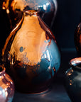 The Copper iridescent glaze is a shiny, smooth metallic glaze with many variations. Some pieces end up with a blue-gray flashing of color that covers a portion of the surface.