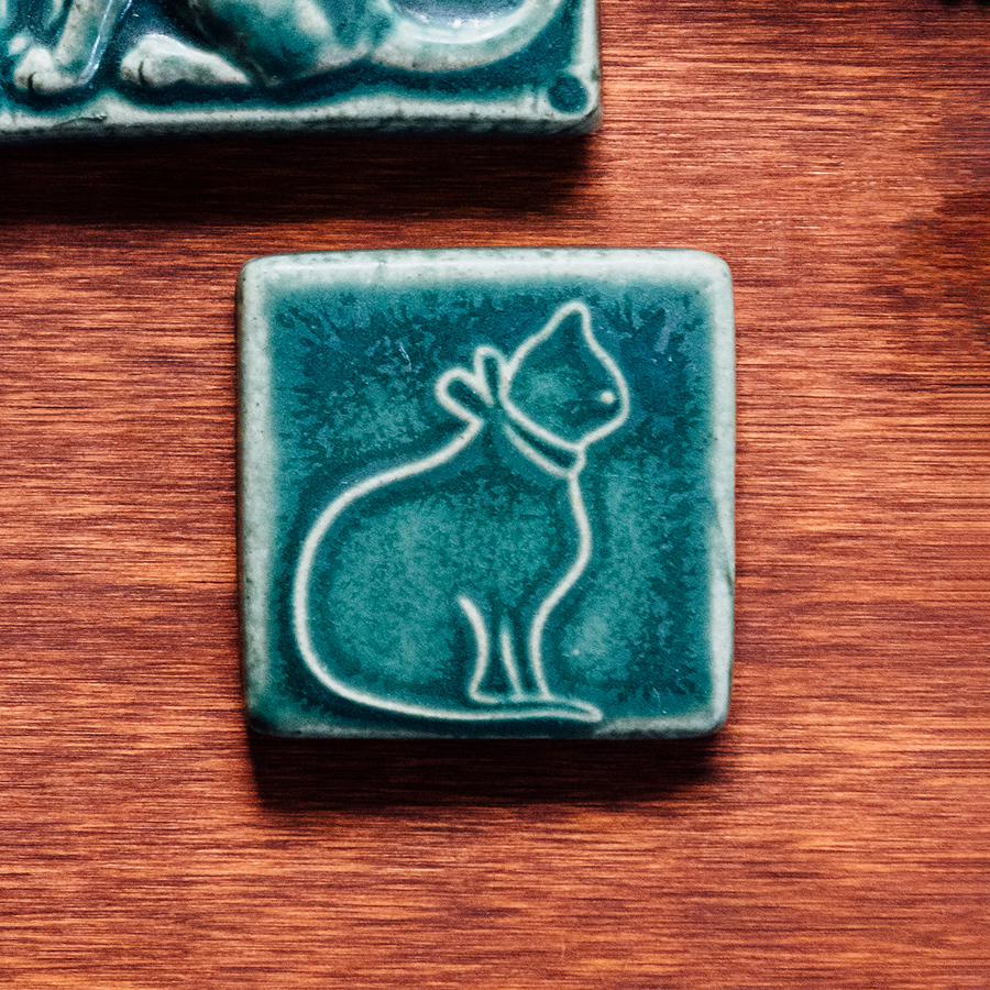 This ceramic cat tile is featured in the matte blueish-green Pewabic Green glaze.