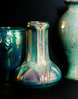 The Matte Green Iridescent glaze on this Celtic vase has many variations. Some pieces have a shiny blue-green metallic finish while others have a matte, flat appearance similar to brushed metal.