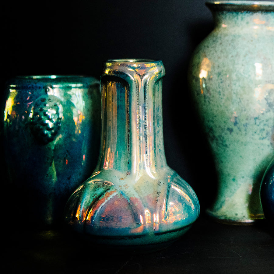 The Matte Green Iridescent glaze on this Celtic vase has many variations. Some pieces have a shiny blue-green metallic finish while others have a matte, flat appearance similar to brushed metal.