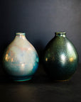 Two Teardrop vases feature the extremely variable Matte Green Iridescent glaze. One vase has a shiny blue-green metallic finish while the other has a matte, flat appearance similar to brushed metal.