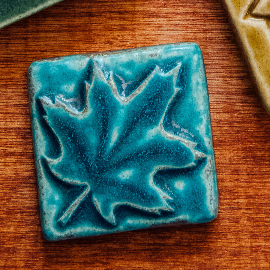 The Pewabic blue glazed maple leaf tile is featured. This tile is a matte turquoise blue.