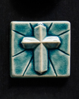 The Mario's Cross Tile features a geometric 3d cross with simple lines emanating from it. This tile features the medium blue Glacier Gloss glaze.