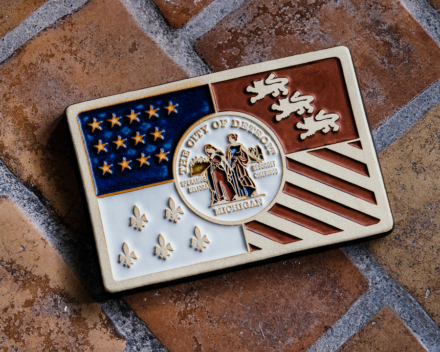 A hand-painted tile features the city of Detroit Flag design.