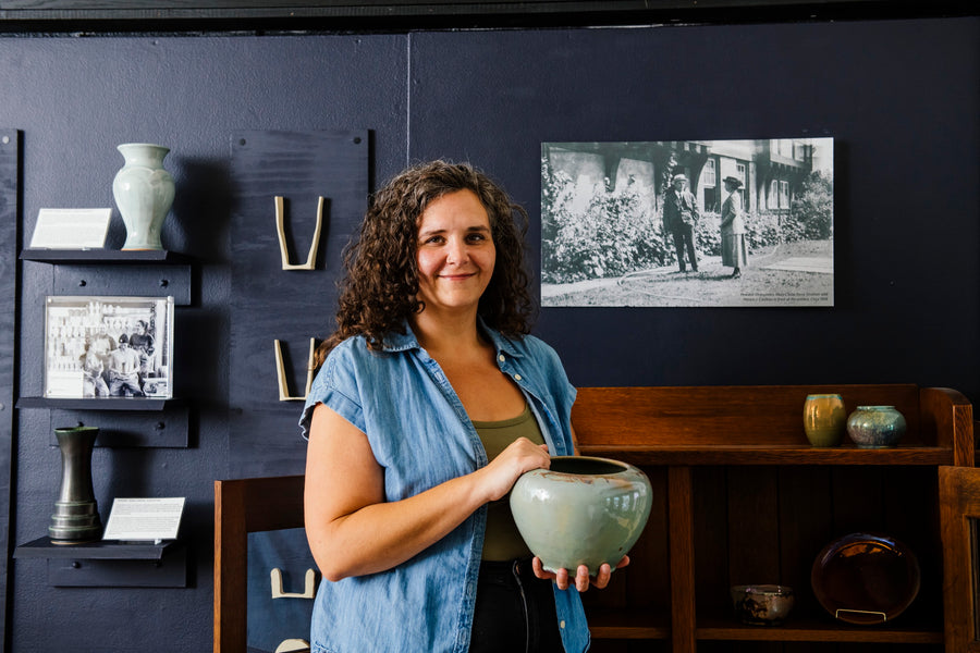 Pewabic archivist Anne Dennis poses with a historic vase from our museum collection.