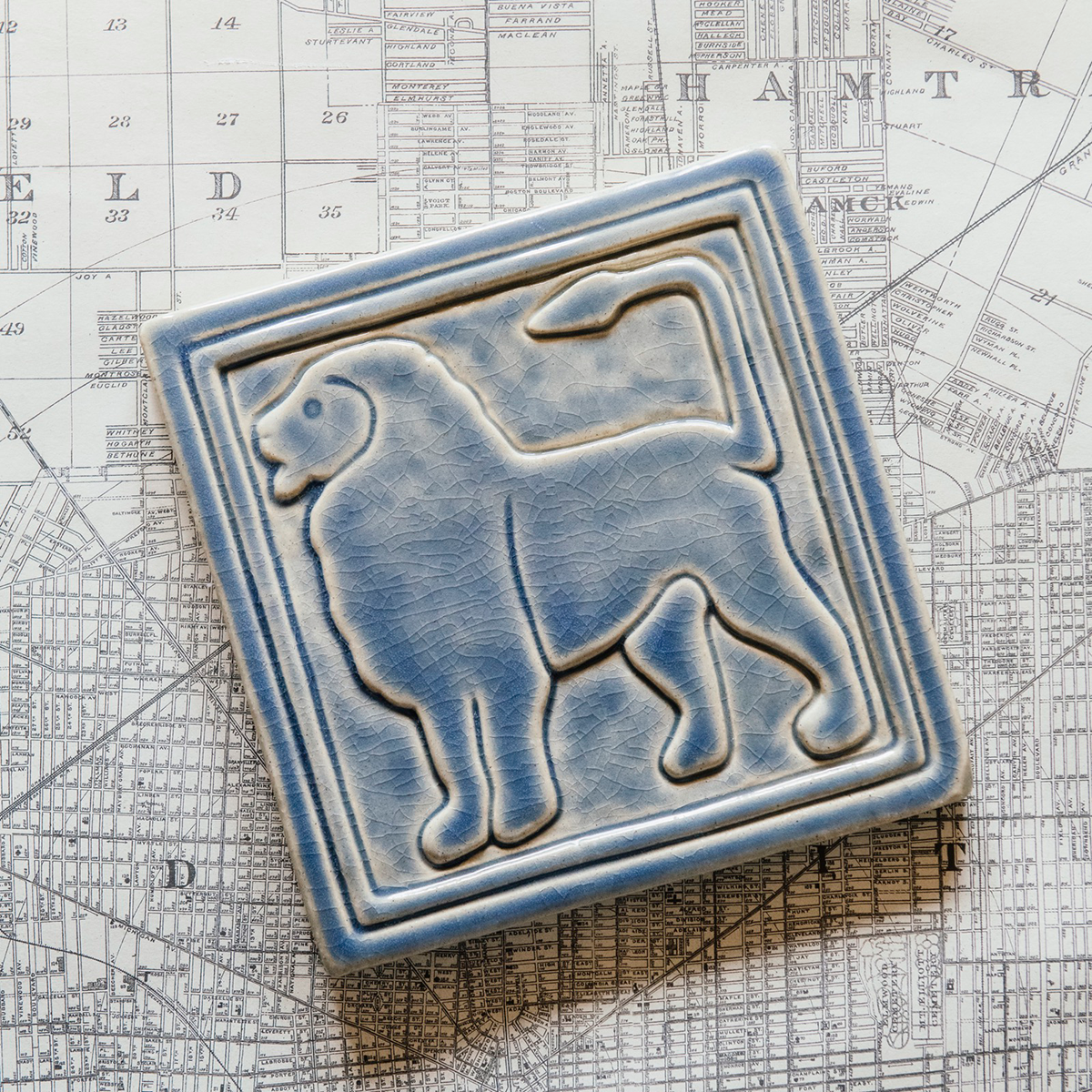 The left-facing Lion tile in the Dusk glaze sits on a black and white map of Detroit.