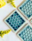 The Honeycomb tiles feature a flat line drawing of a honeycomb pattern with a simple smooth border around it.