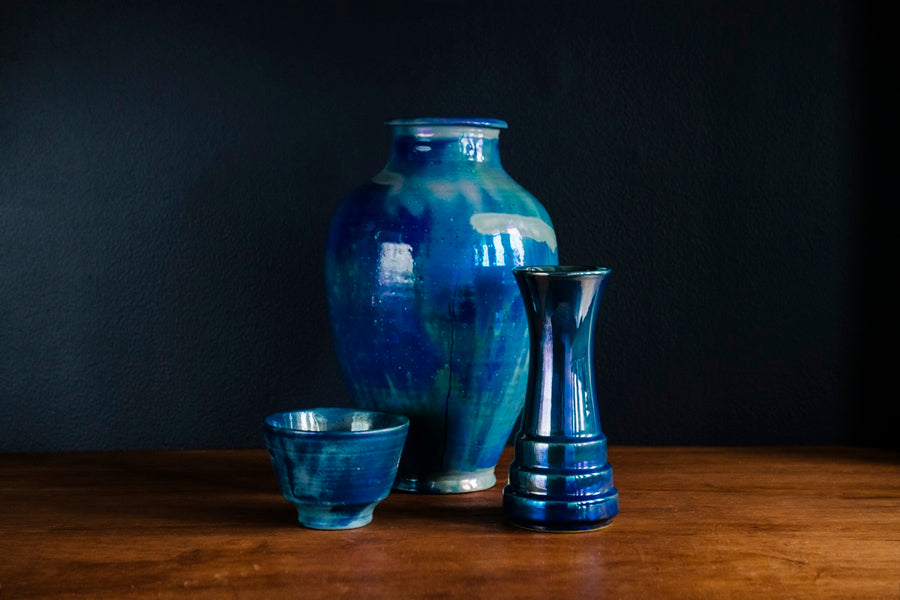 A new Azurite iridescent Step Vase is displayed among blue historic iridescent pieces found in our museum.