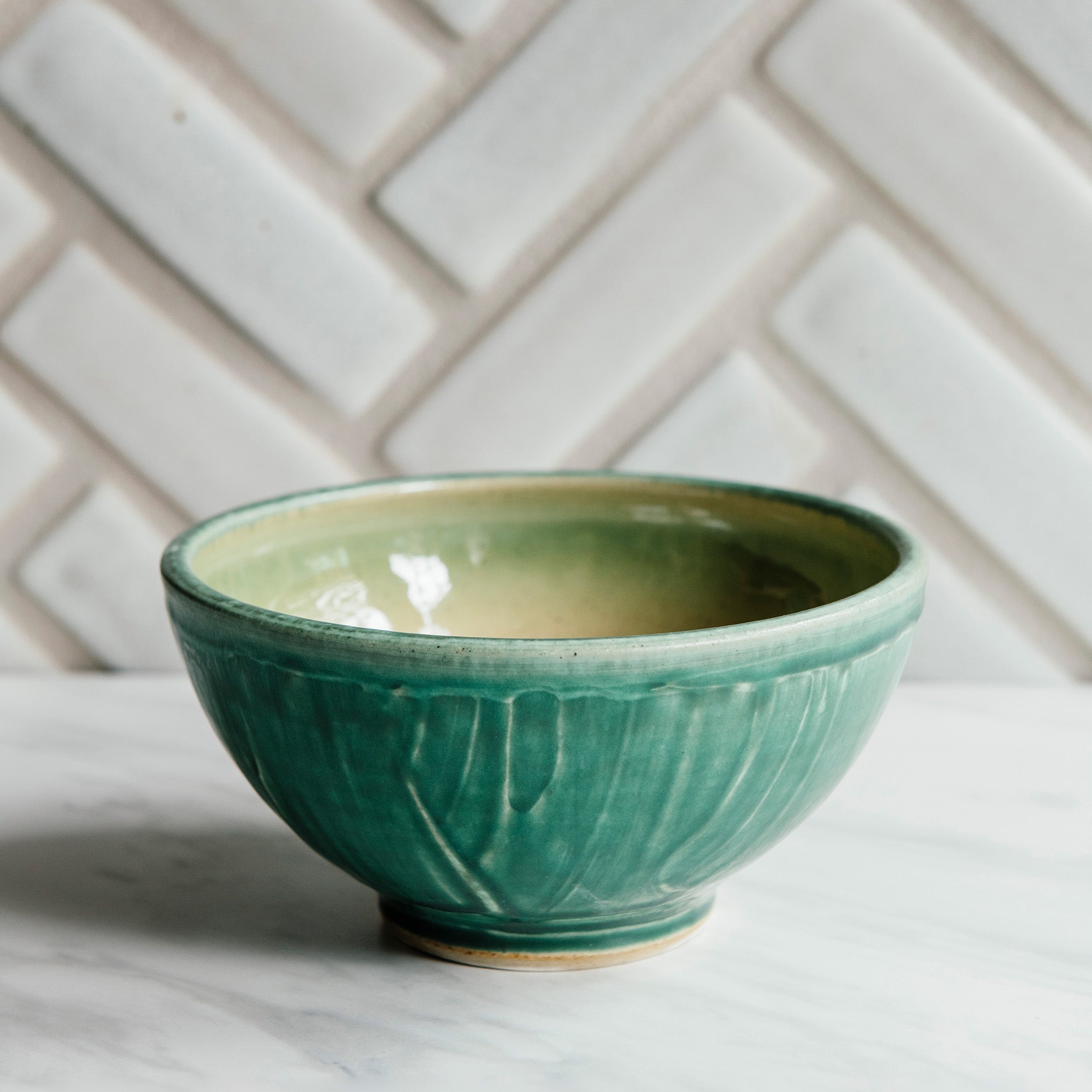 This bowls features the matte blueish-green Pewabic Green glaze.