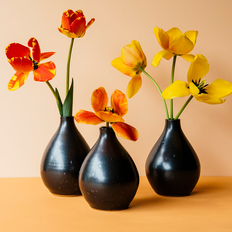 A trio of Teardrop Vases with bright, red and yellow tulips on a bright orange backdrop