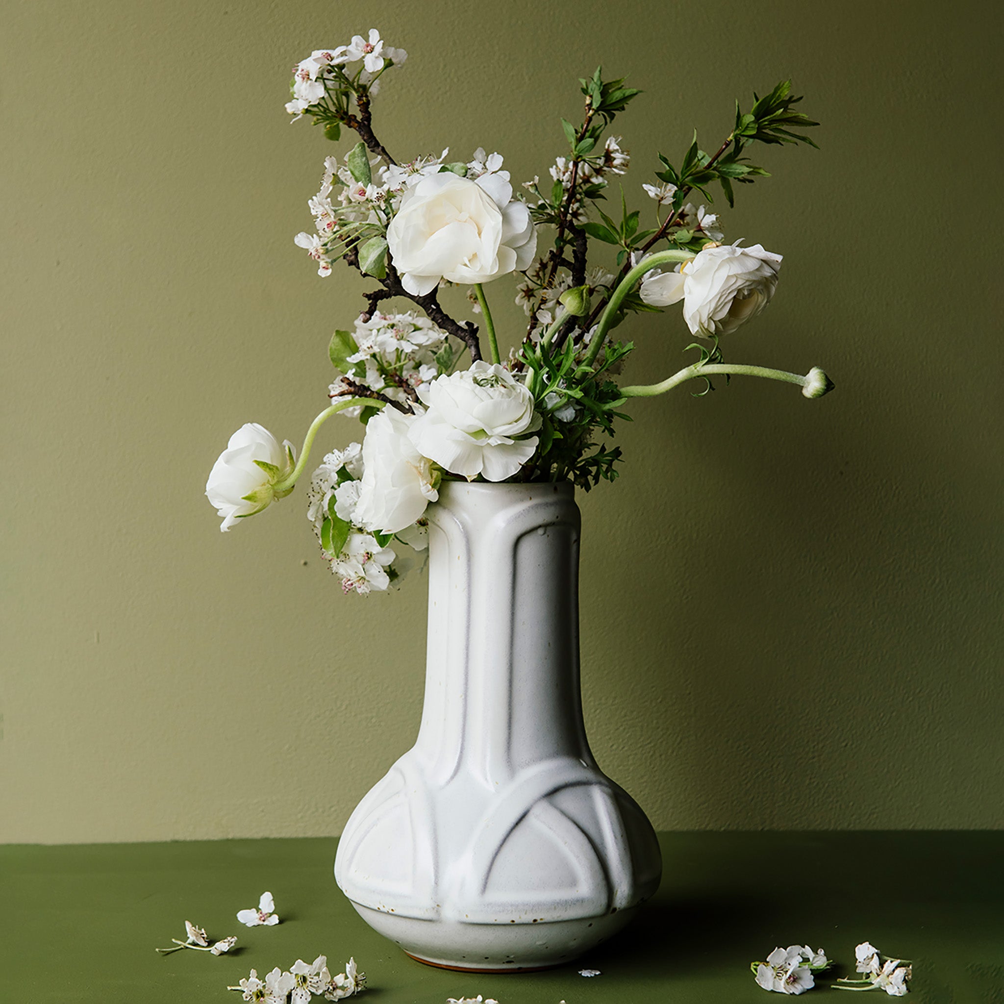 The Celtic Vase's base starts out wide and round at the bottom then becomes a straight pillar as it continues upward with a winding line design that has no beginning or end. 