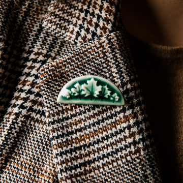 The green tones of the Maple Leaf Pin are a perfect contrast pinned to a black and brown houndstooth blazer.