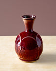 The Winterberry glaze is a rich, dark red color with a smooth, glossy finish. The glaze breaks at the raised portions of the vase, letting the ivory of the clay body poke through and giving the piece depth of color.