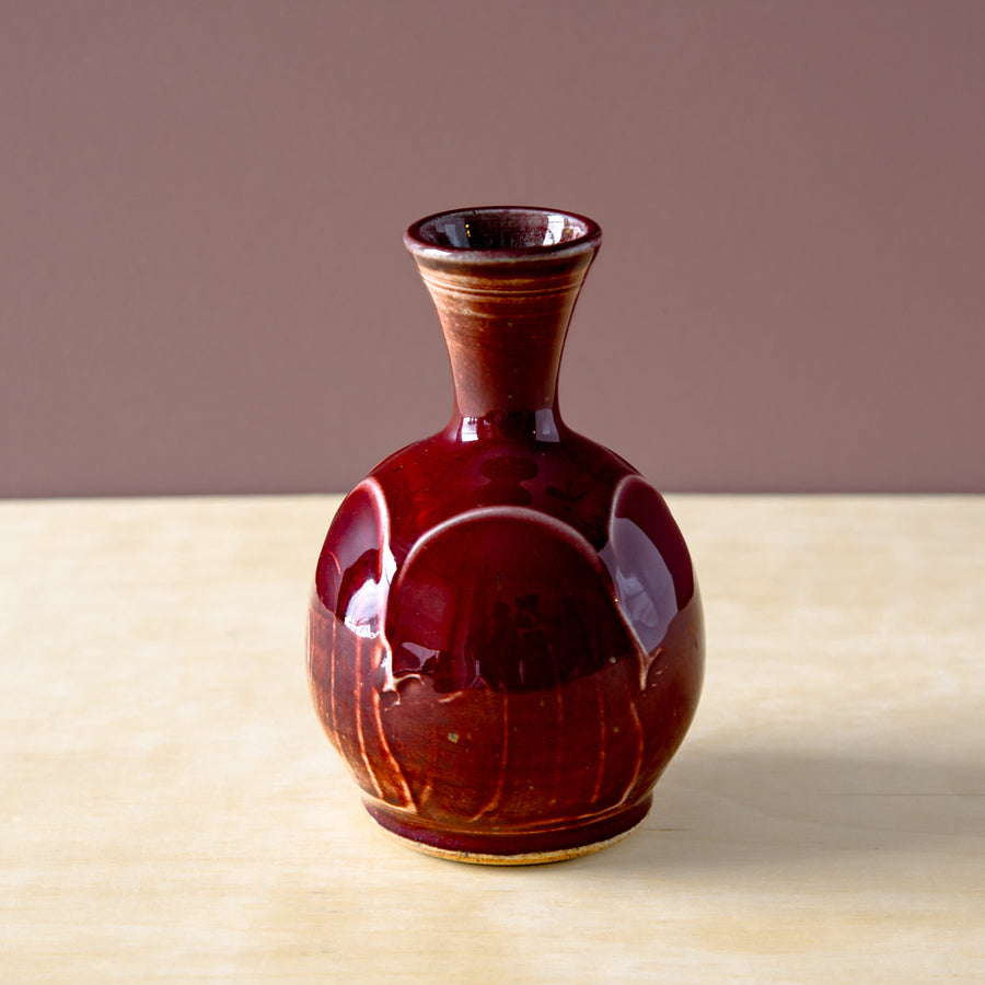The Winterberry glaze is a rich, dark red color with a smooth, glossy finish. The glaze breaks at the raised portions of the vase, letting the ivory of the clay body poke through and giving the piece depth of color.