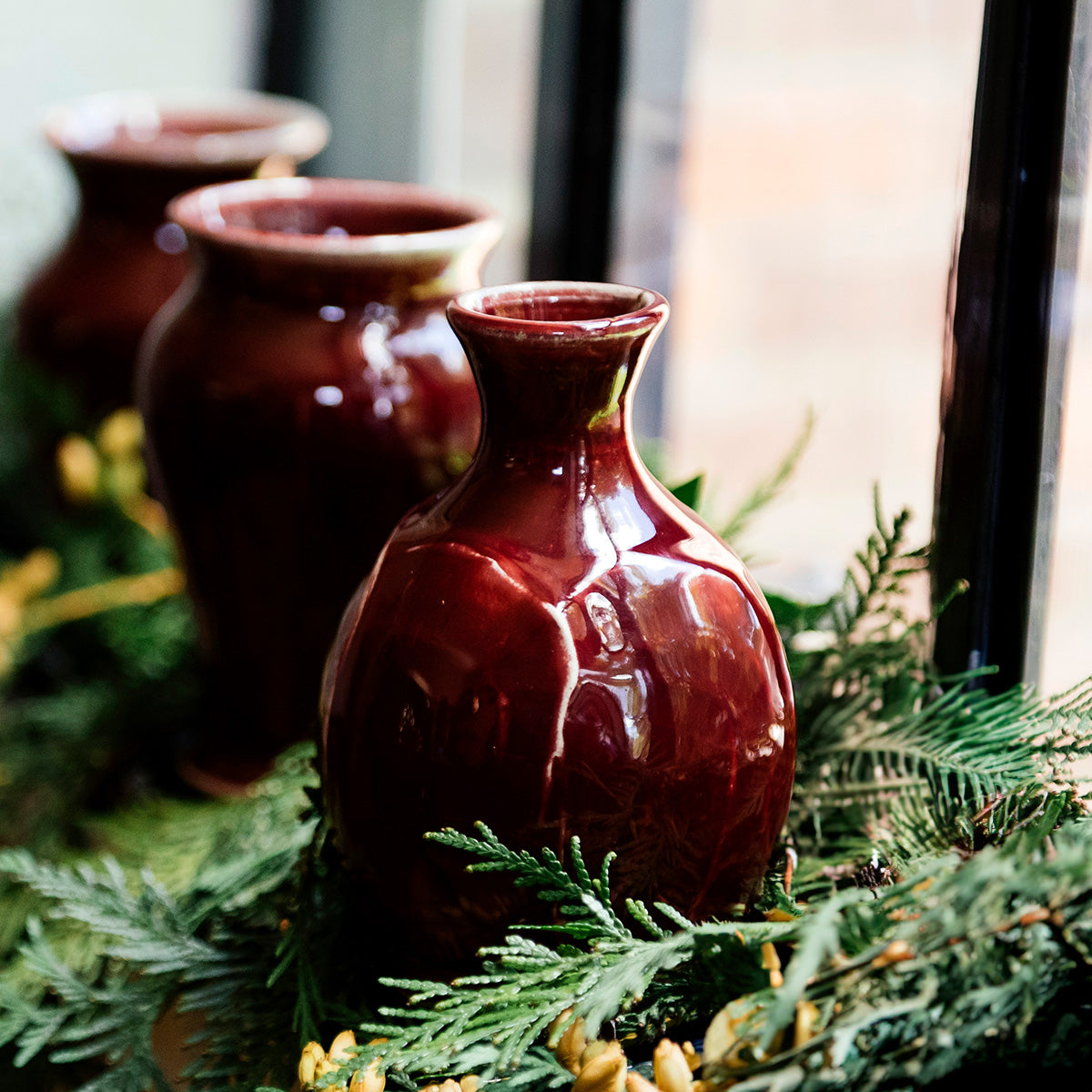 The Bud Vase has a bulbous shape, mimicking the roundness of a flower bud, with slip added to the sides by hand to create a petal-like appearance. From the round bottom emerges an organic tall opening at the top to keep your flowers straight up.