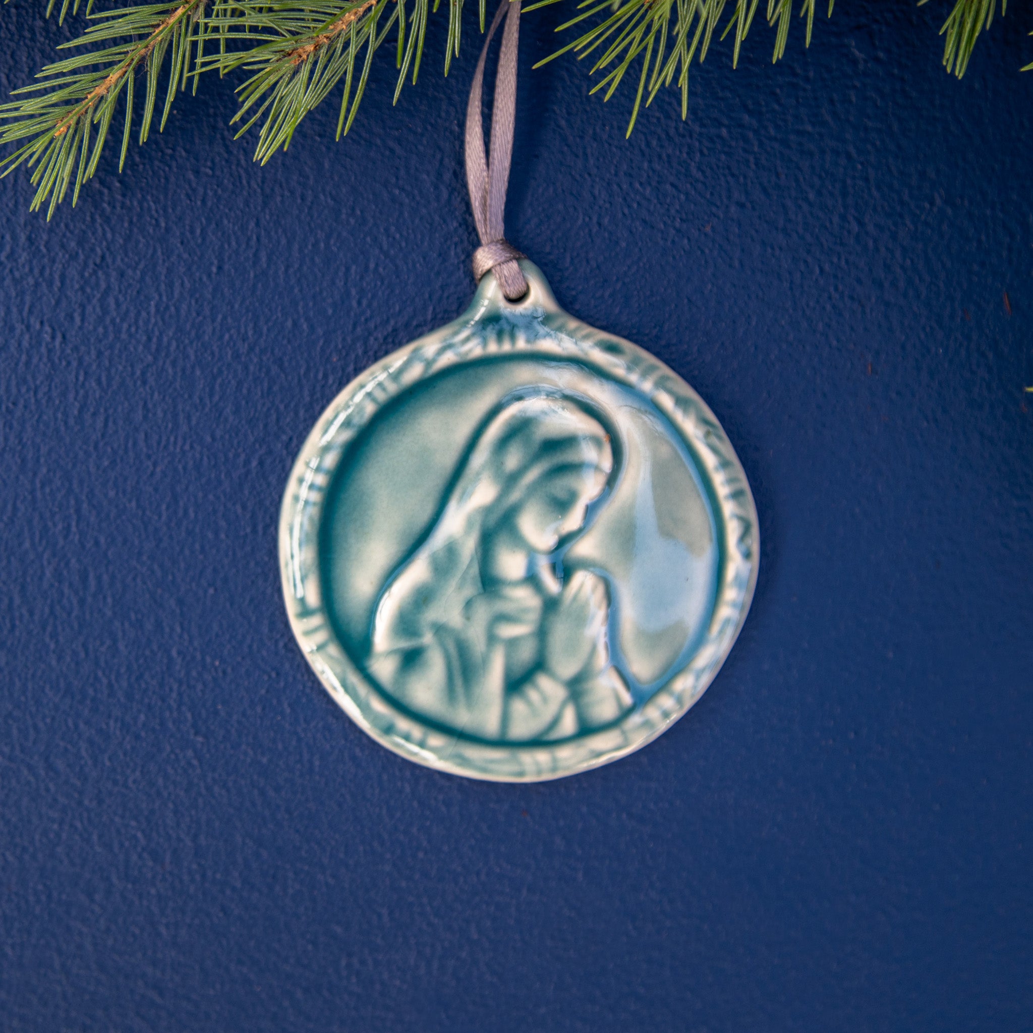 This ceramic Blessed Virgin Mary Ornament is glazed our calming, glossy, light-blue Glacier glaze with a delicate ribbon string in shimmering taupe. 