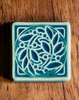 Leaf and Berries tile features the Mist/Marine color palette. The raised portions of the tile are the matte pale blue Mist glaze while the background is the matte dark blue Marine glaze.