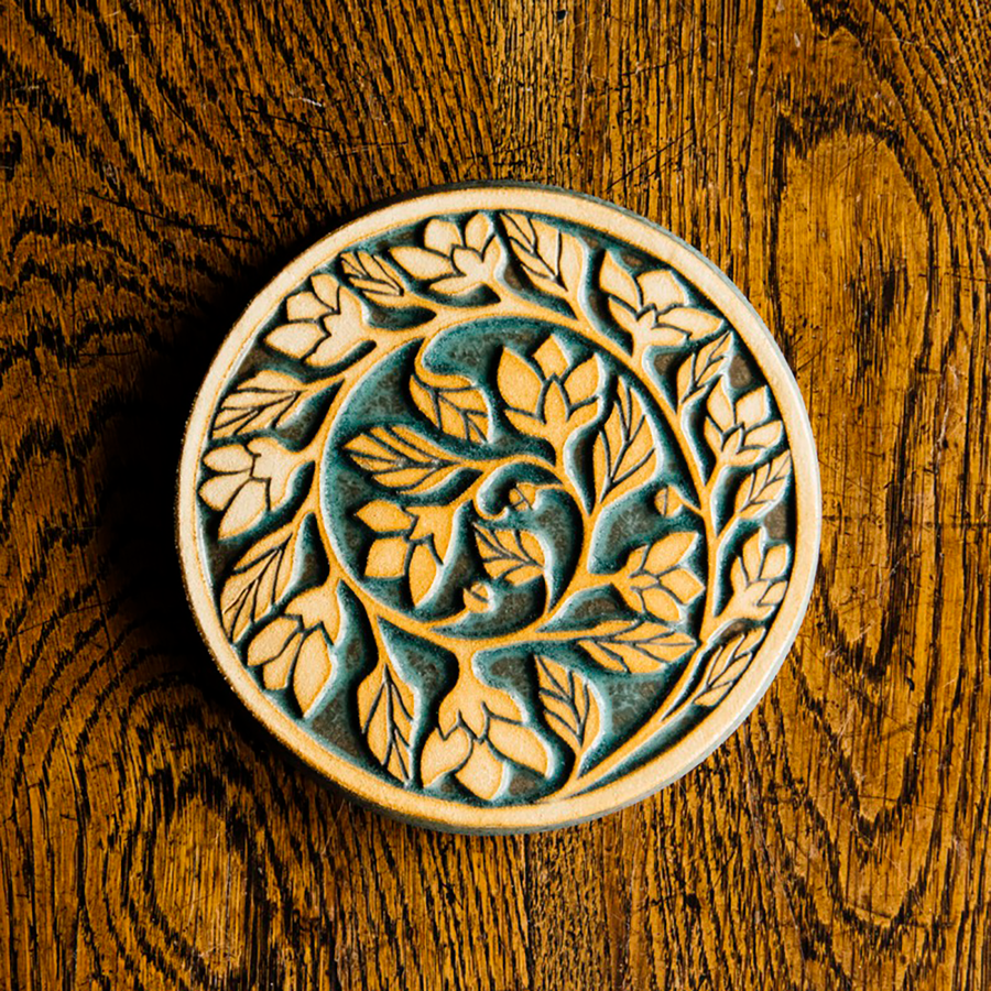 The two tone nature of the tile means that the ivy is scraped to give a creamy white color while the background is in the crystalline, shimmering deep green Viridian glaze.