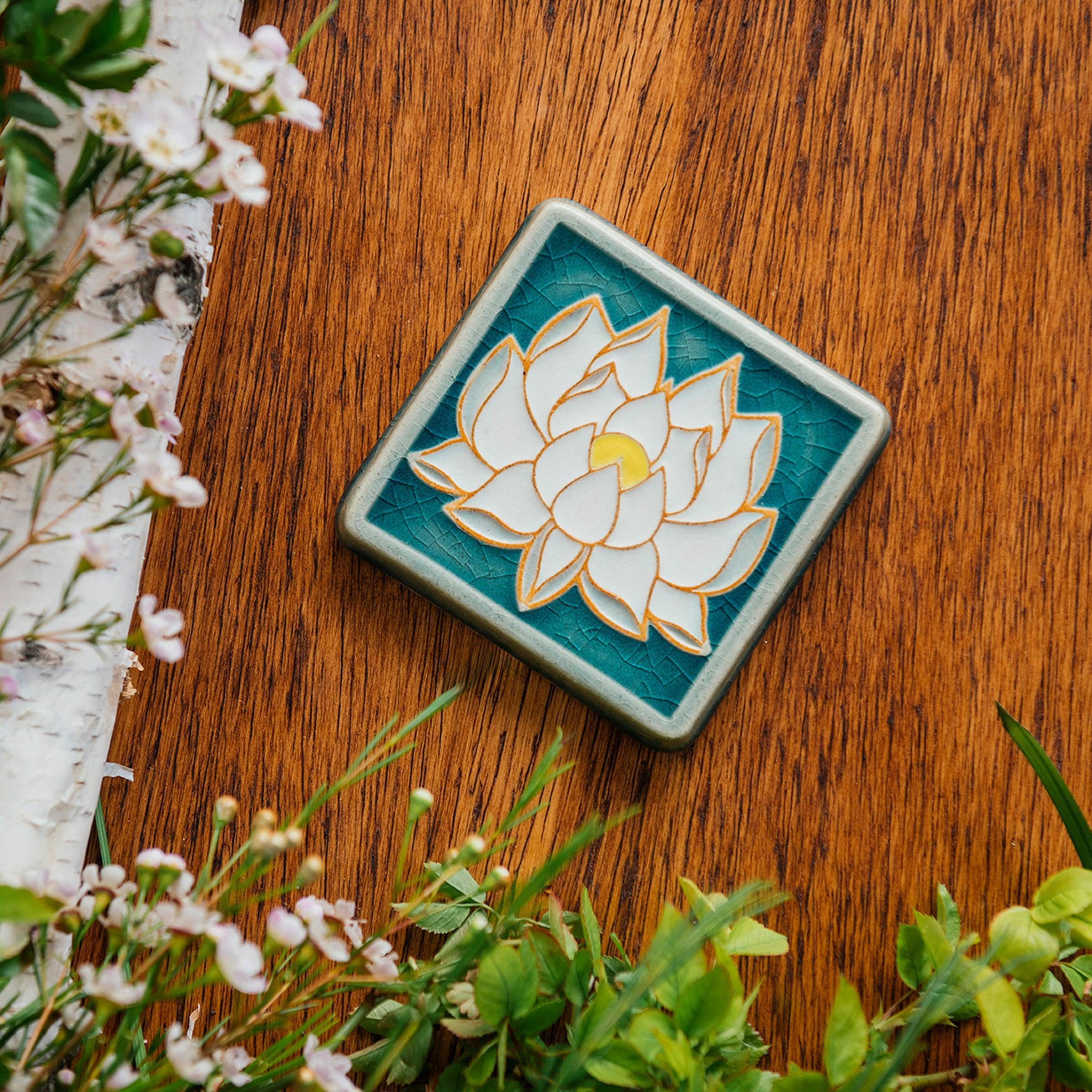 The Lotus tile features a line drawing of a blooming lotus flower, its pointed petals outstretching. It has a simple border around the design.