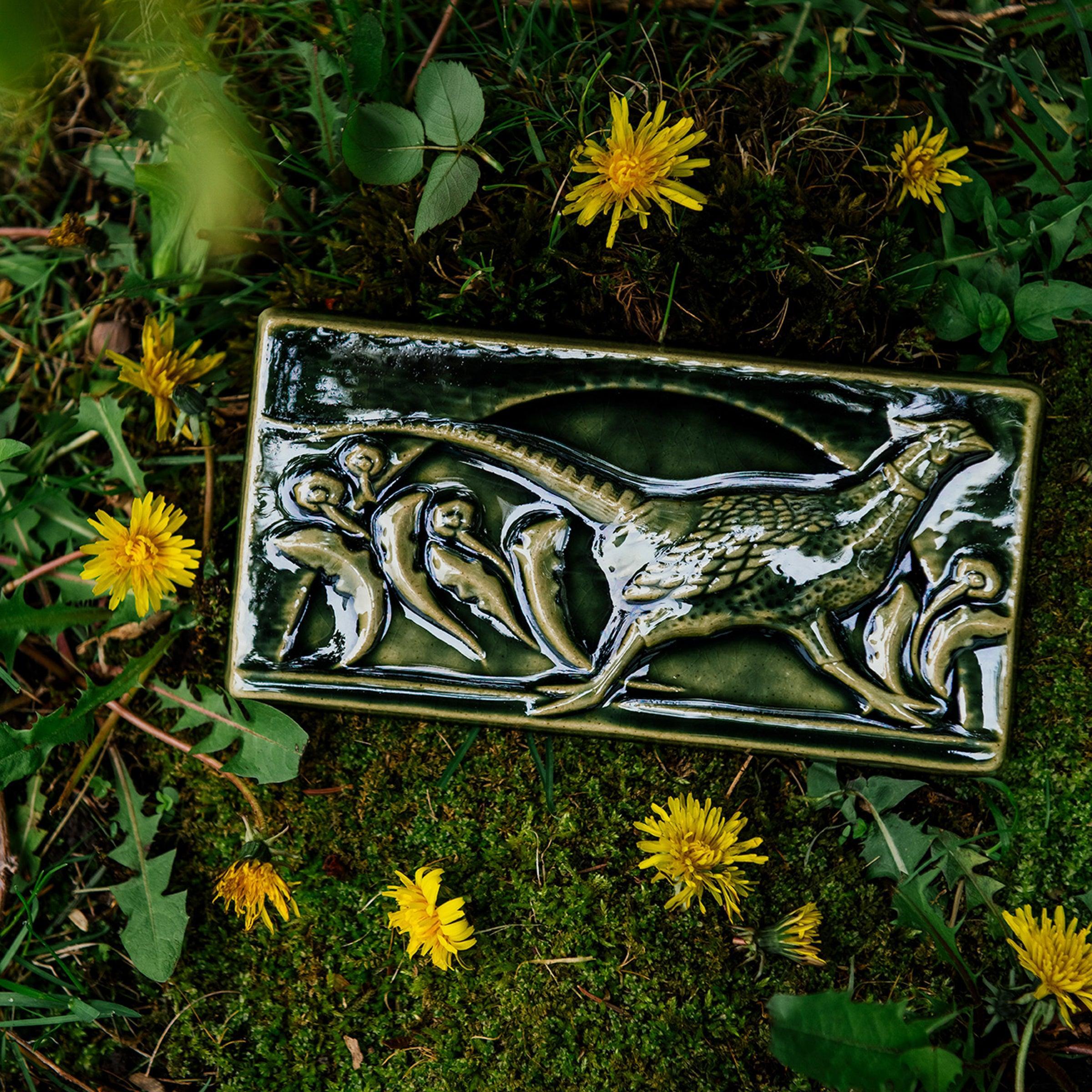 This hand-sculpted tile features a pheasant running through a field of dandelions. It is featured in a glossy green Kale glaze. 