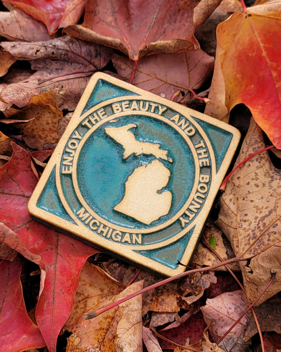 The viridian/scrape version of the Michigan tile is glazed in the crystalline deep green glaze called Viridian. Before firing, the tile has been scraped, leaving the raised design without color.