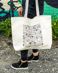 The On The Rocks tote bag has a creamy white background with black line drawings of many different shapes and sizes of cups and mugs.