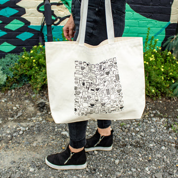 The On The Rocks tote bag has a creamy white background with black line drawings of many different shapes and sizes of cups and mugs.