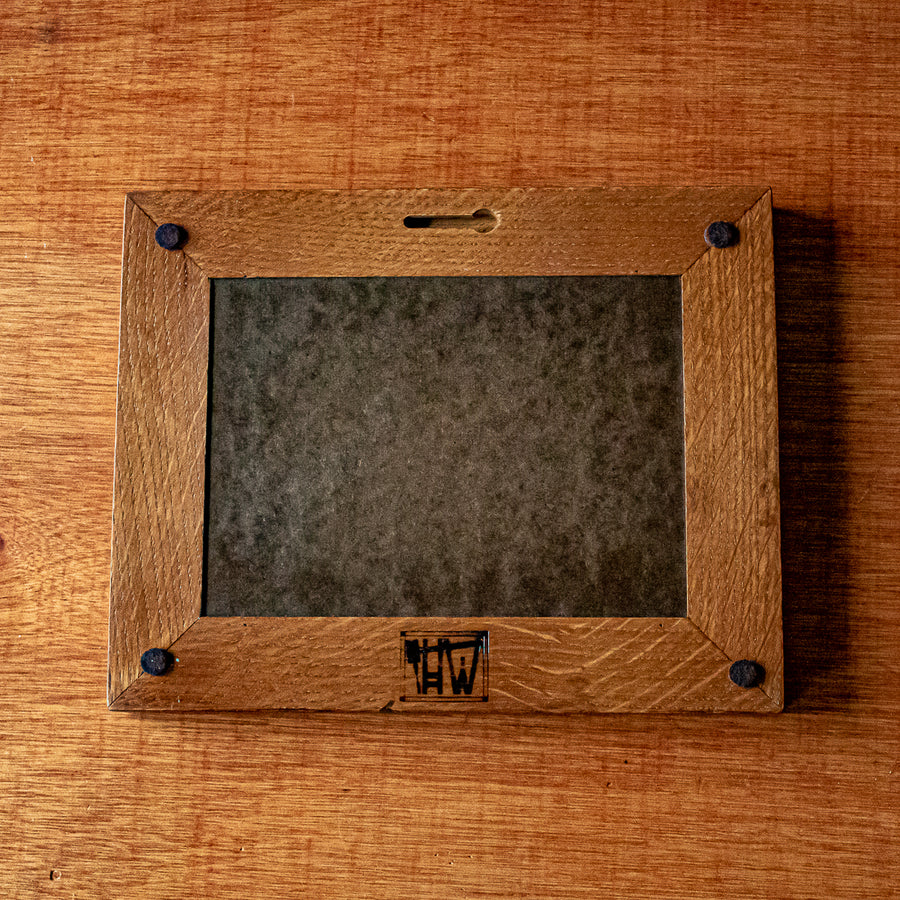 The back of the framed tile includes four small felt pads to protect your walls and there is a burned logo reading "HW" - for Henige Woodworks, the maker of this frame. The back of the tile is covered with a darker wood backing.