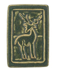 The ceramic Deer Tile features a stag with its body in profile - but its head is turned to the viewer, showing off its large antlers. There is a thick border around the design. The entire tile is featured in our matte dark mossy green Bayleaf glaze.