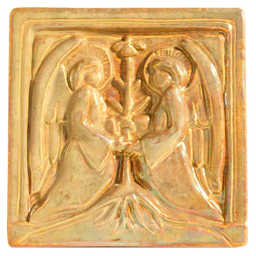 This square tile shows two angels in flowing robes with large feathered wings face each other, each has their hands grasping a bare tree growing between them. The Blush Iridescent glaze is a bright metallic gold.