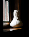 A Snowdrop vase sits on a windowsill, the light trickling in seems to warm the ceramic.