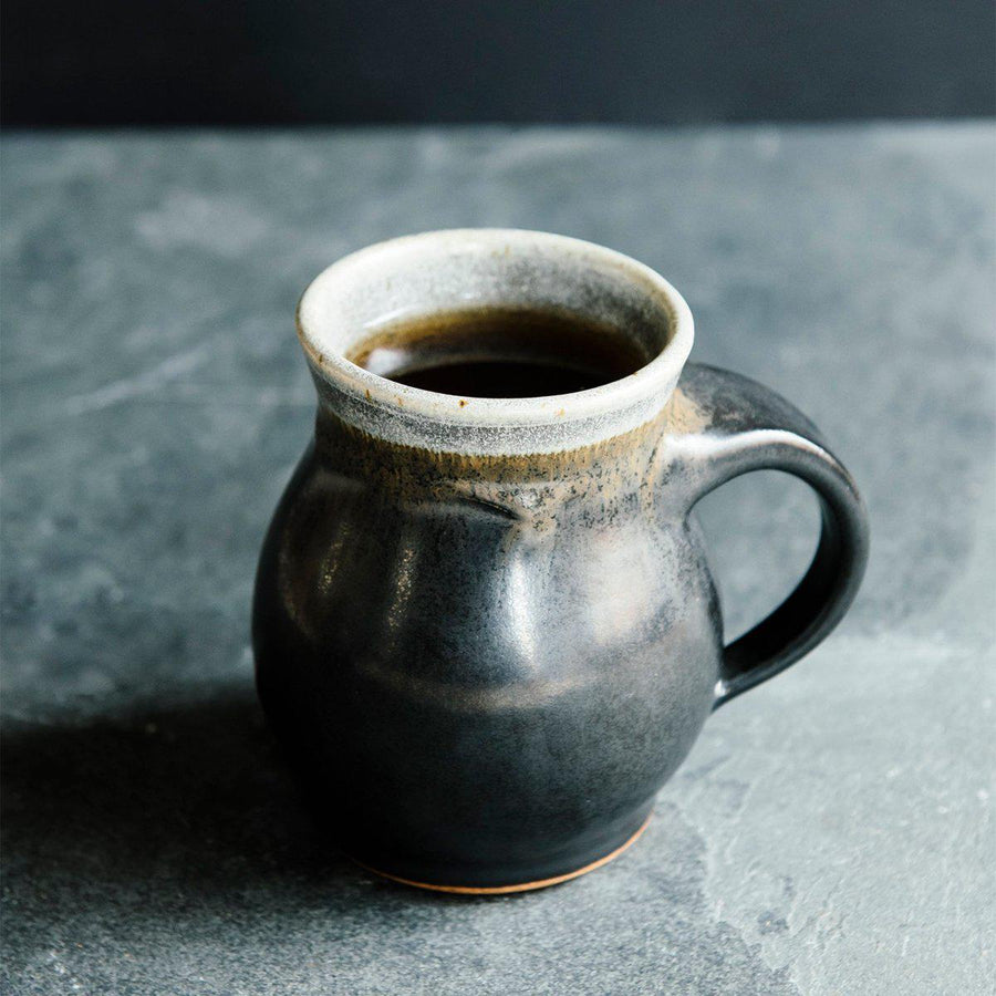 The Classic Mug is has rounded sides with a more narrow opening for drinking. The main body of the mug is the main glaze color while the inside and the lip are a coordinating color. This mug features the almost graphite looking black Carbon glaze with a gray lip.