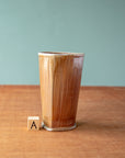 The style A pale brown tumbler boasts a semi-gloss glaze and a slight triangle shape.