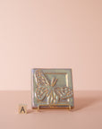 A butterfly tile sits on a stand next to the letter A to delineate which option is represented.
