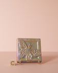 A butterfly tile sits on a stand next to the letter C to delineate which option is represented.